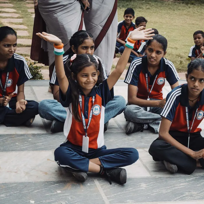 A girl raising her hand among classmates