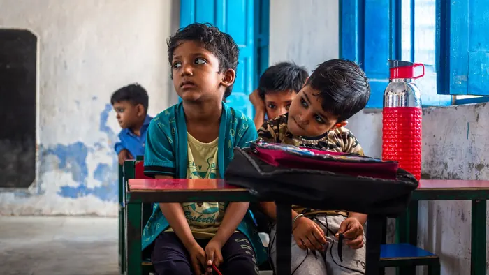 Children sitting together in a colourful classroom