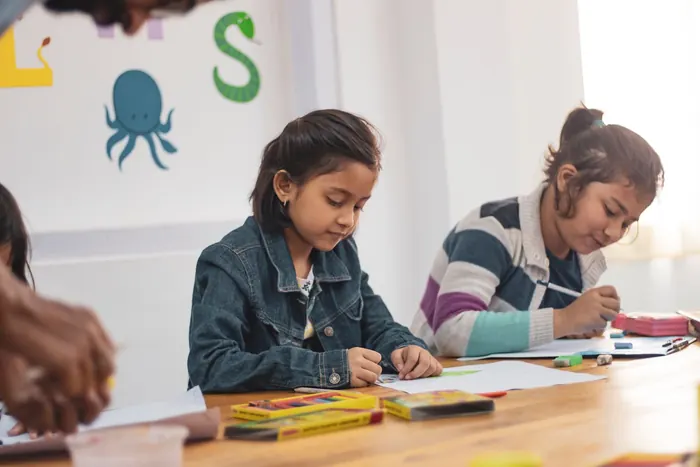 Two girls drawing together at a table